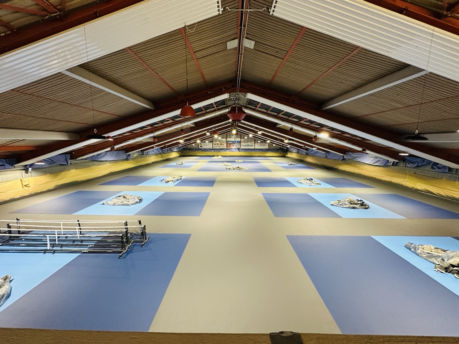 Die Pickleballhalle Grüze während des Umbaus: neue blaue Spielflächen vor dem Markieren der Linien.